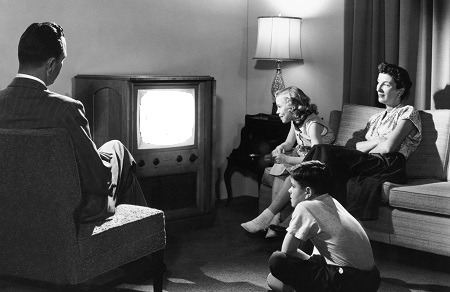 Single family suburban nuclear family watching the television.